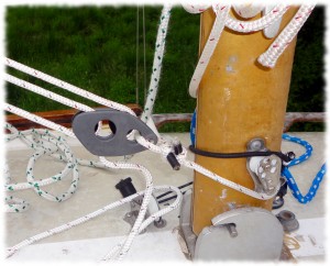 The vang attaches to the mast with a line looped around the mast (and run though an eye strap on the forward edge of the mast)