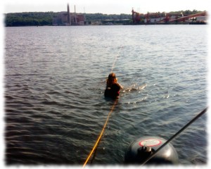 Will and Ben swimming astern of the boat while at anchor in the Thames River.