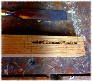 The leg after the the drill press. The remainder of the wood in the mortise will be removed by chisel.
