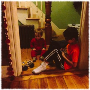 Ben and Michael playing in the hallway. Michael is enchanted by the remote controlled Lego car Ben is driving