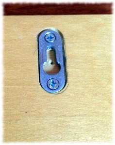 A simple keyhole hanger flush mounted on the back.