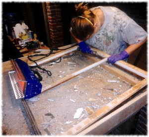 Susanna working on a window sash.