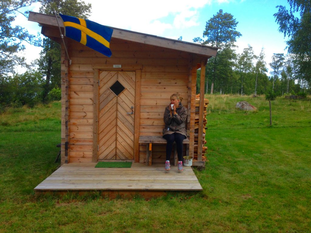 Susanna keeping warm next to the sauna at the cabin on the lake.