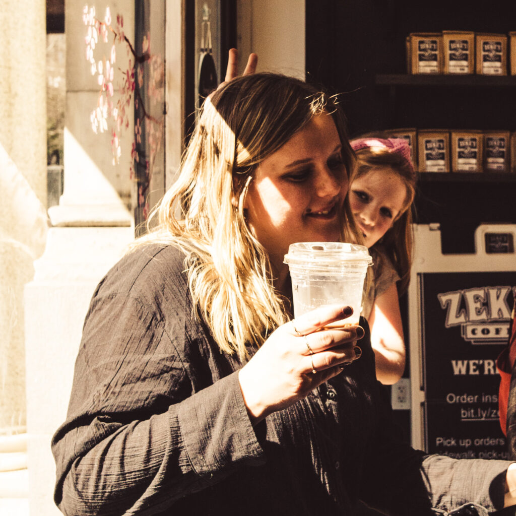 Susanna enjoying a coffee with a little photobomb by Izzy.